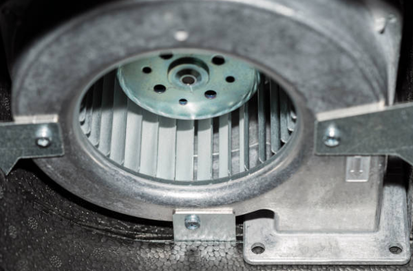 Close-up view of a furnace blower wheel inside a residential HVAC system housing.